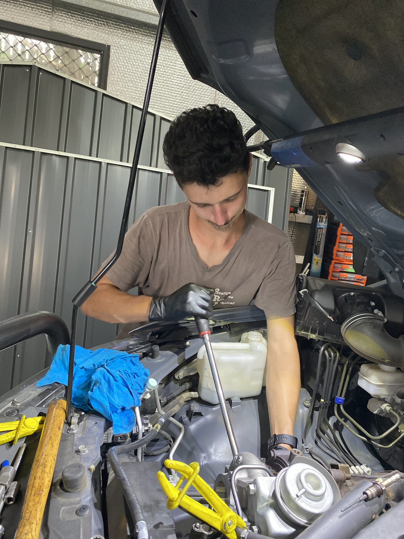 Dylan from Prestige Performance Mechanical working on a vehicle